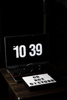 Laptop displaying 10:39 time with a Do Not Disturb sign in a minimalist workspace.
